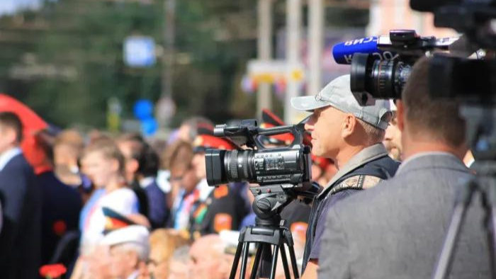 Broadcast reporters with cameras on location at an event