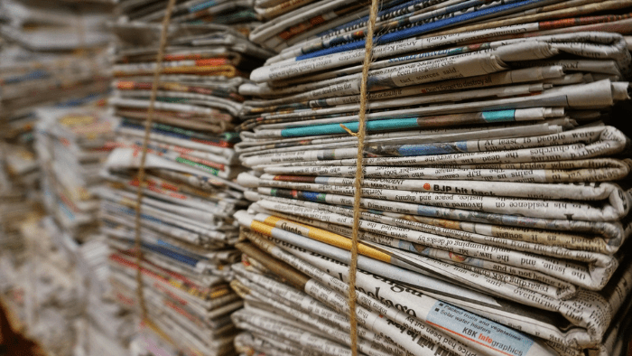 Several stacks of newspapers tied together with twine