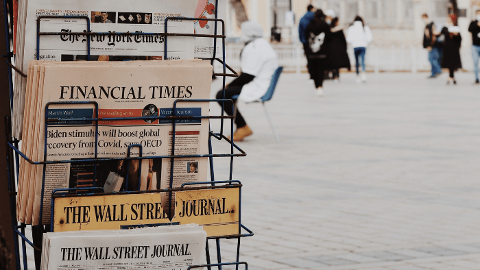 Newspaper rack with copies of New York Times, Wall Street Journal and Financial Times