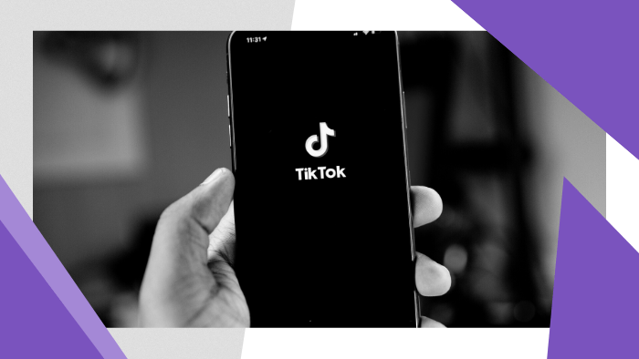 Person holding black iPhone 5 displaying the TikTok logo