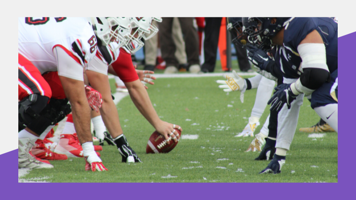 Football teams lined up, preparing for a play