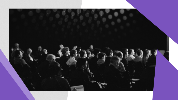 Crowd of people sitting, listening to a presentation