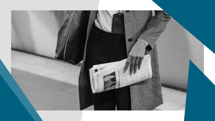 Person holding a folded newspaper