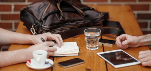 two people sitting at a table taking notes