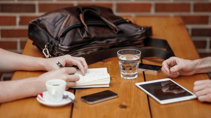 two people sitting at a table taking notes